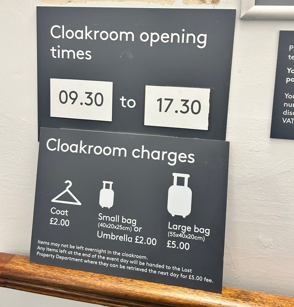 A cloakroom sign with the opening times of 09:30 - 17:30 and prices for various items. 